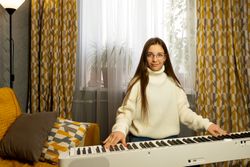 Girl with long hair playing the piano at home.