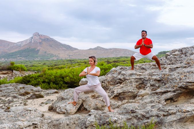 Couple meditating on rock