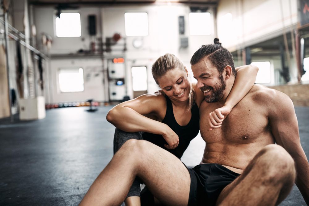 Man and woman with their arms around each other on gym floor