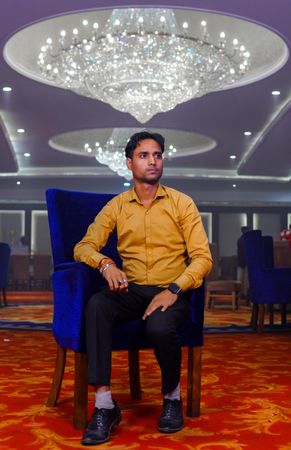 Young man sitting on blue armchair