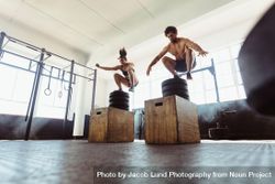 Healthy man and woman box jumping at gym 43WdR4