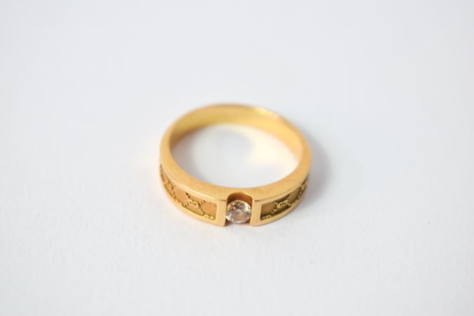 One diamond gold ring on plain table with space for text