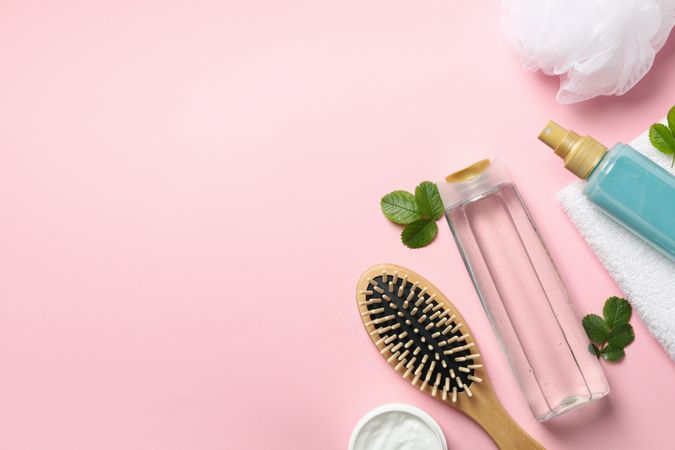 Composition of personal hygiene with bottles of cosmetics on pink background