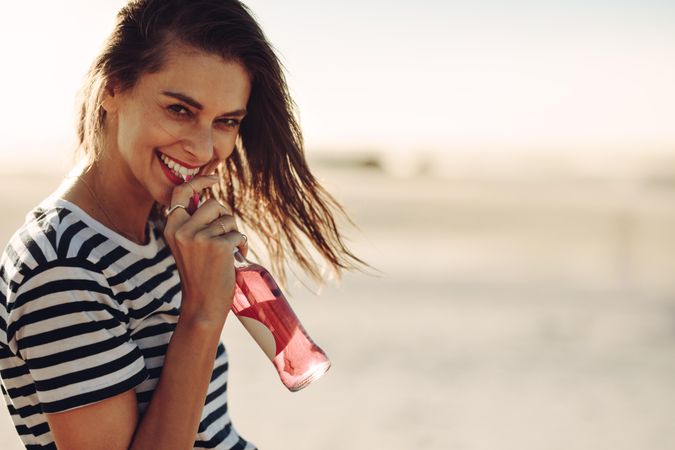 Young smiling woman drinking a soft drink on summer day