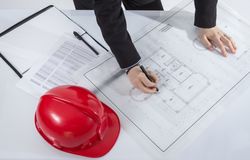 Above view of architects hands revising a house project