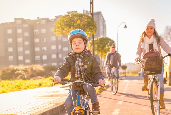 Little boy leading mom and dad on family bike ride