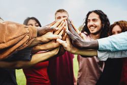 Joyful group of multi-ethnic community of happily joining hands in the park