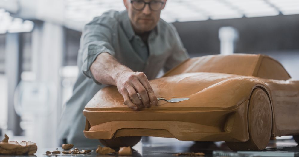 Close Up Portrait of an Automotive Designer Sculpting a 3D Clay Model of a New Production Car.
