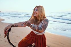Joyful woman riding bicycle along peaceful beach