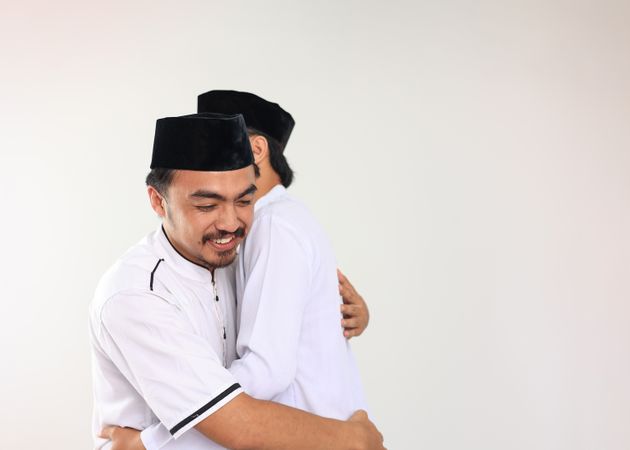 Two Young Indonesian  Muslim Male Hug and Smiling during Eid Al Fitr Festive