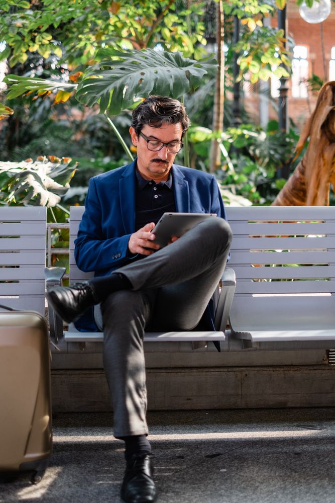 Mature handsome man using digital tablet outdoors