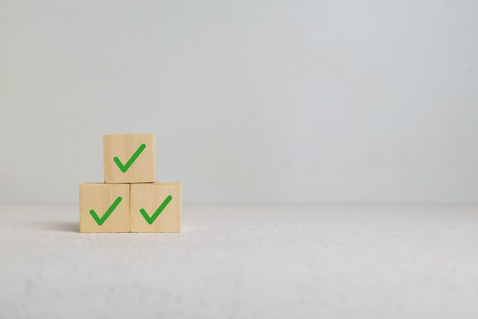 stack wooden blocks with checkmark symbol isolated on light background