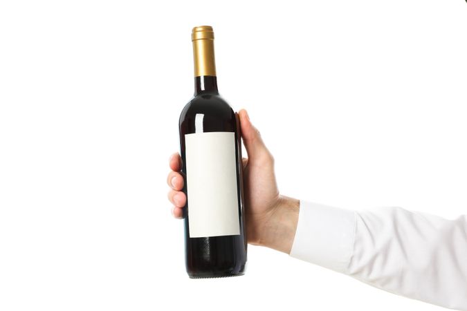 Male hand holding bottle of wine, isolated on plain background