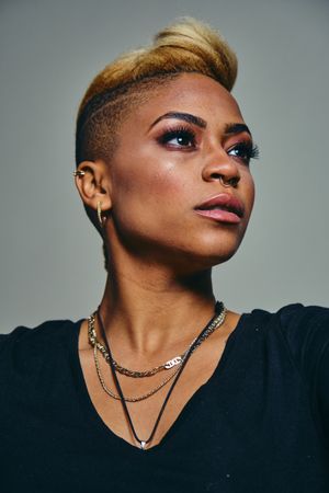 Closeup portrait of serious Black woman with septum piercing looking away from the camera