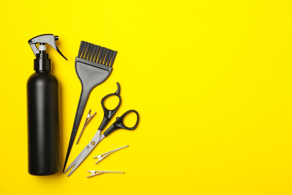 Composition with hairdresser accessories on yellow background, space for text