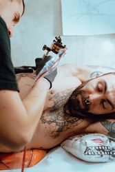 Man giving client a tattoo