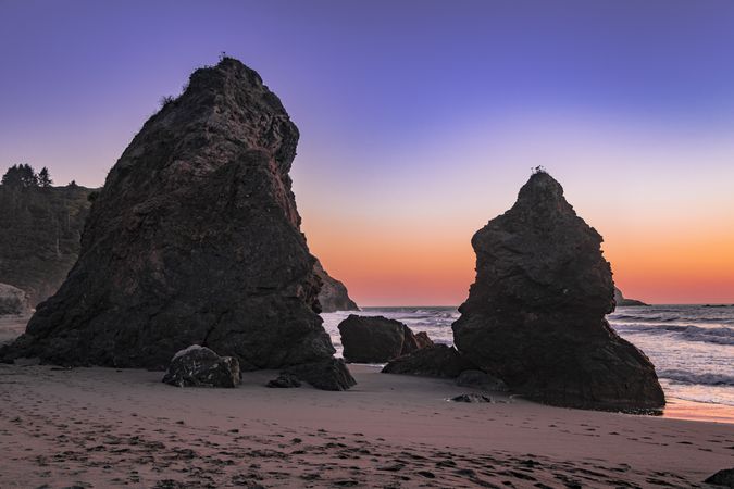 Sunset over Pacific Ocean seen from rocky beach