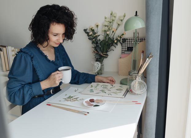 Painter sitting with cup of coffee at work