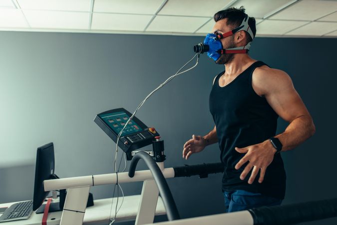 Athlete examining his performance in sports science lab running on treadmill