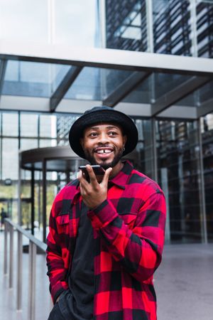 Cheerful Black man talking on smartphone on street