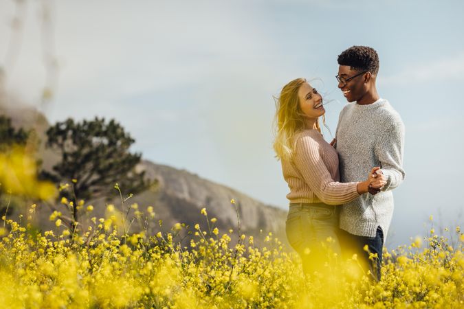 Couple in love dancing in meadow of yellow flowers