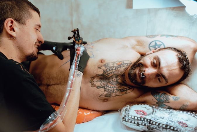 Client receiving tattoo from artist