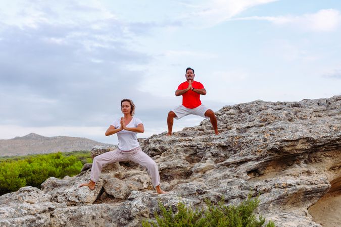 Couple meditating on rock