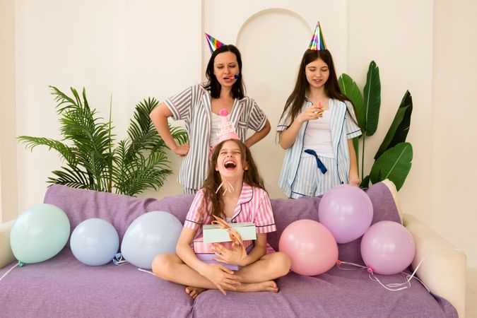 Laughing family with party accessories celebrating birthday at home.