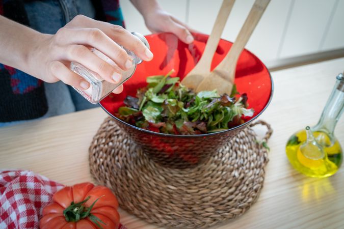 Crop woman preparing vegetable salad