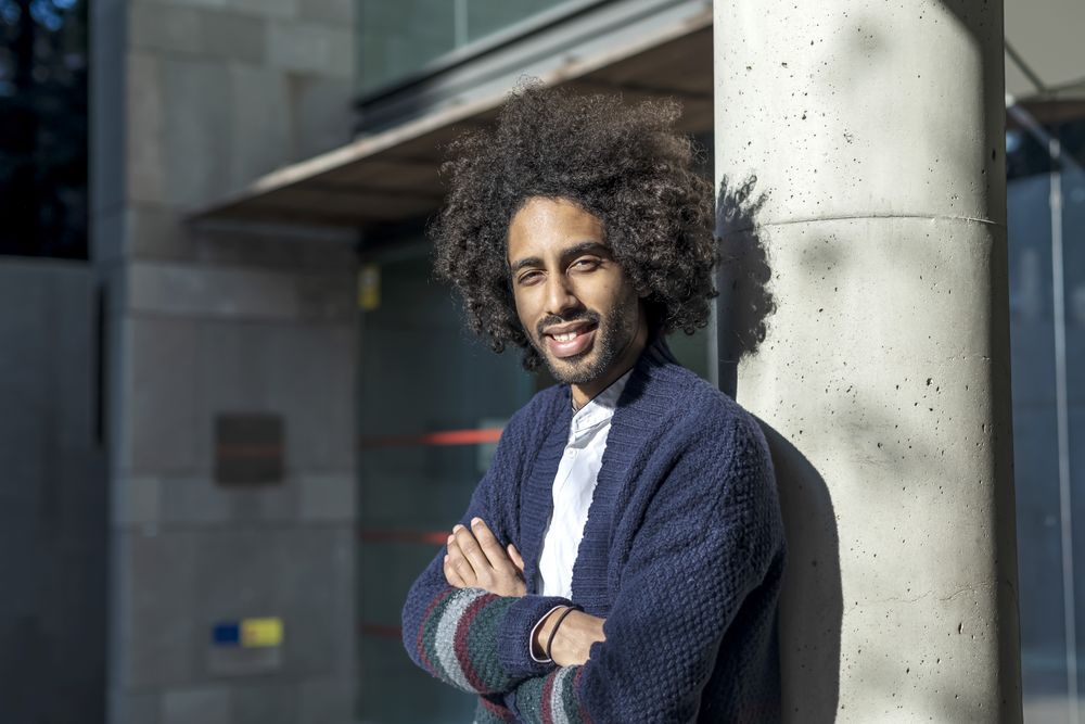 Black man standing with arms crossed on sunny day