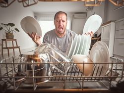 Man crying near dishwasher in kitchen
