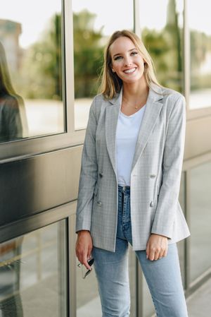 Woman in blazer standing outside offices