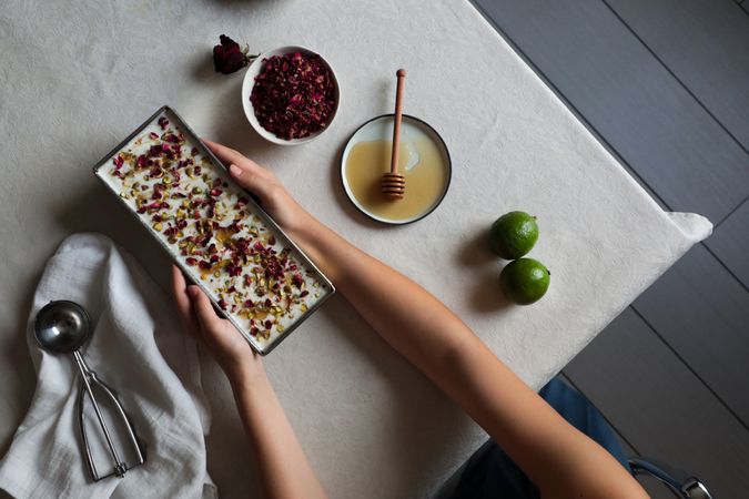 Crop hands putting cheesecake on table