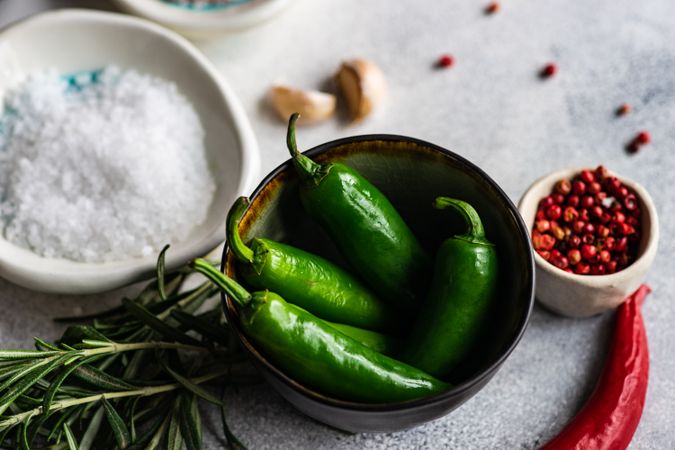 Green peppers surrounded by seasoning for cooking