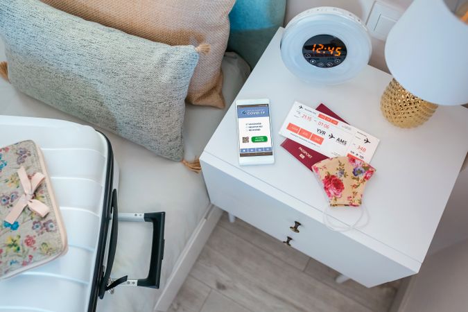 Bedside table with covid passport and preparations to travel