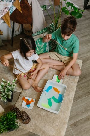 Children playing fishing game at home