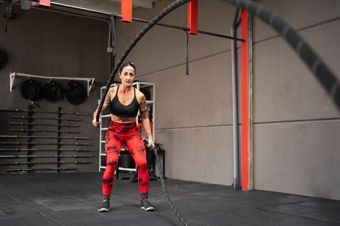 Strong woman exercising with battle rope