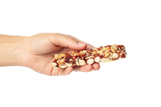 Female hand hold granola bar, isolated on blank background