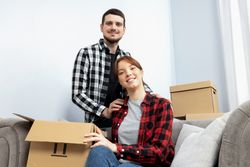 Moving concept, couple man and woman with boxes in apartment.