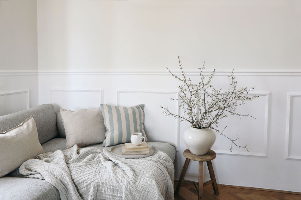 Sofa with linen pale blue striped cushions and cup of coffee