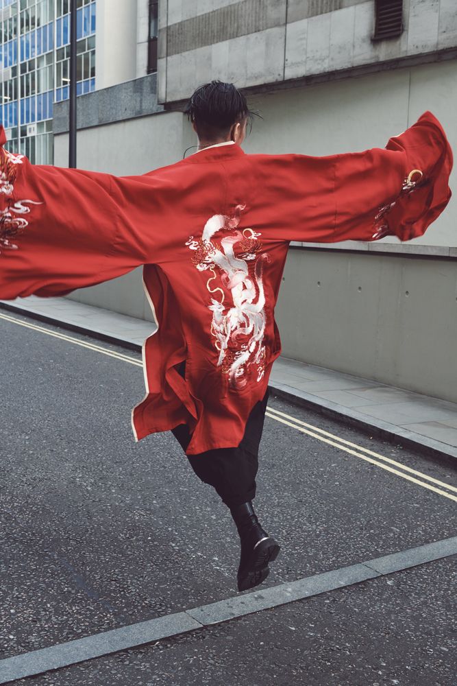 London, England, United Kingdom - September 18 2021: Man skipping in red robe with dragon