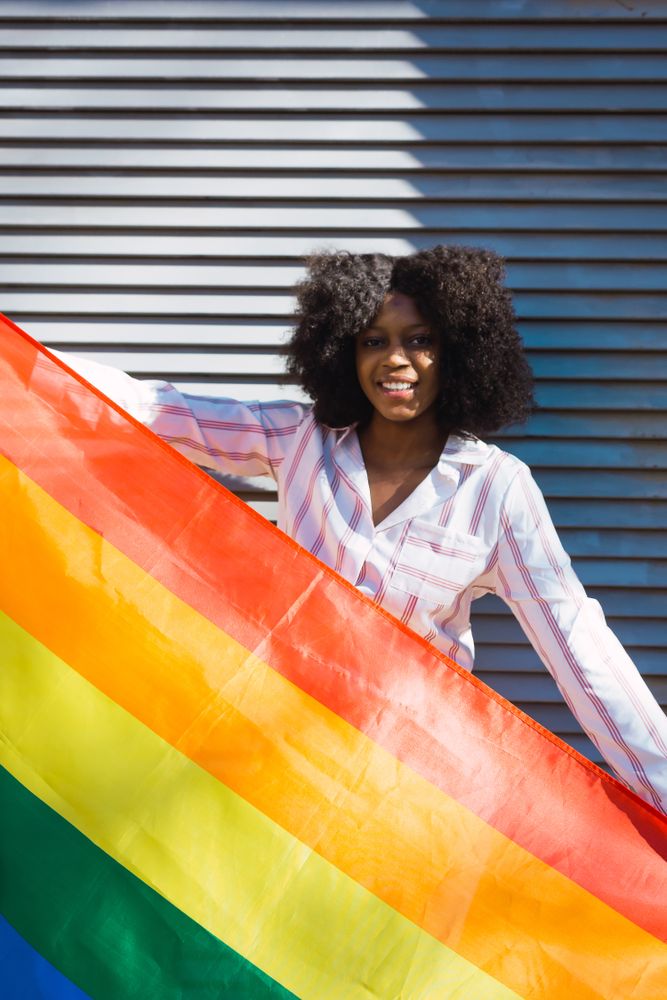 Female posing happily with the LGBT flag