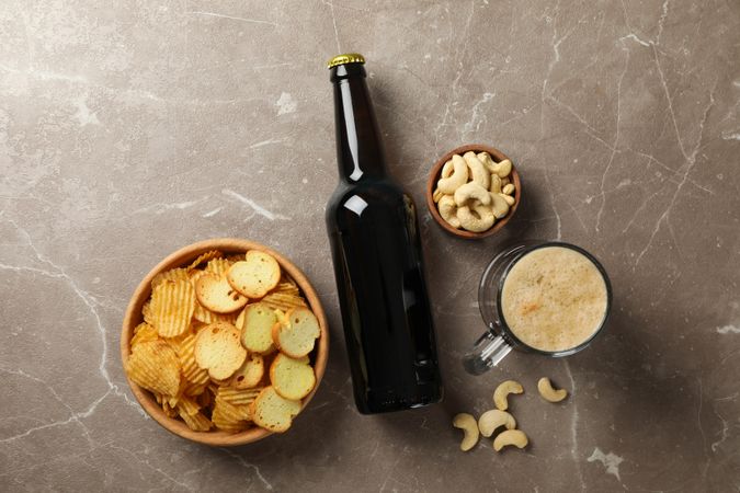 Beer and snacks on gray background, top view