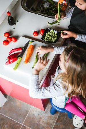 Siblings preparing vegetables for salad