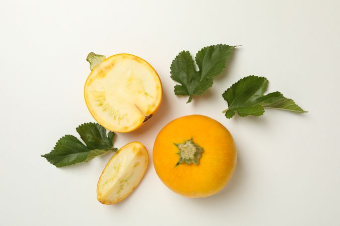 Round zucchini and leaves on neutral background