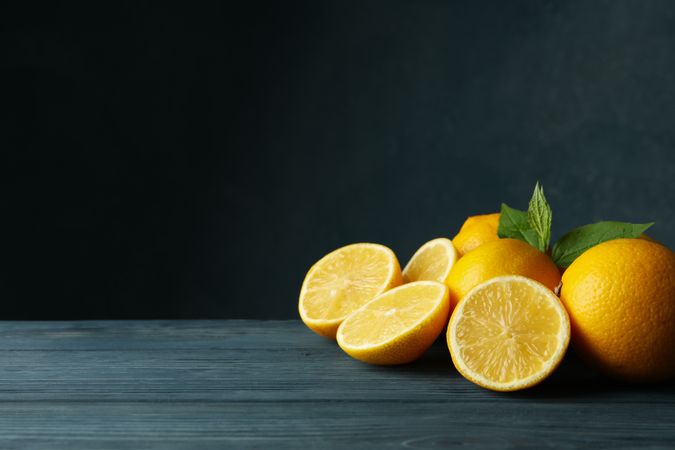 Fresh lemons and leaves on wooden table. Ripe fruit