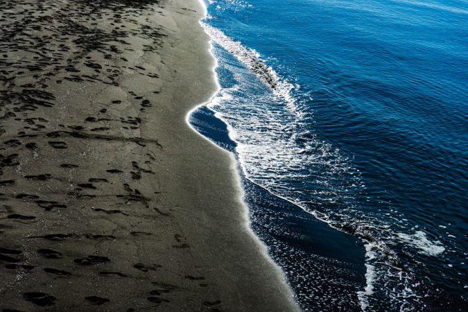 Dark volcanic sand beach and sea