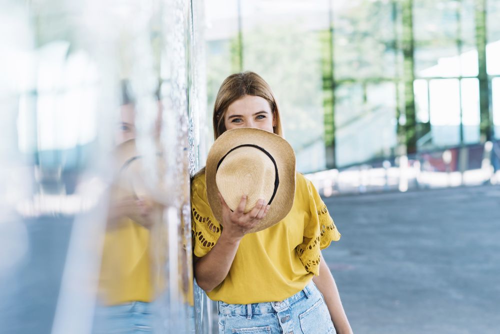 Woman with blue eyes holding straw hat