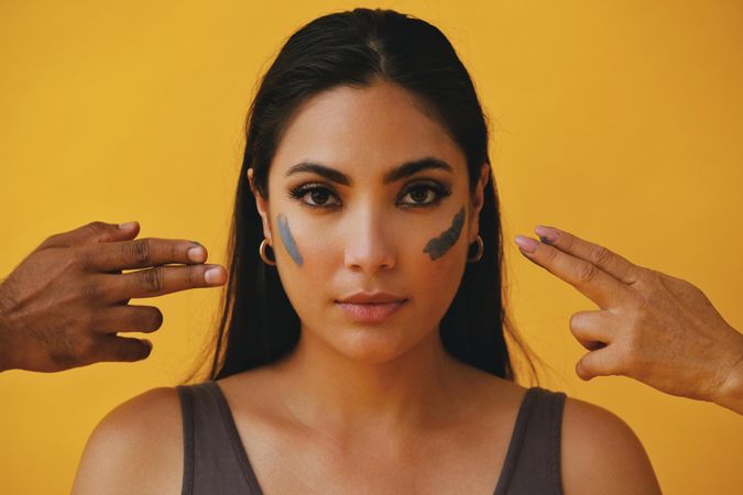 Latina woman with different hands outreaching to apply mud mask, copy space