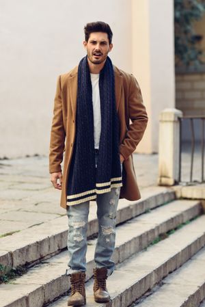 Man wearing winter clothes stopped on outdoor stairs talking